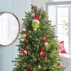 A Christmas tree decorated with Grinch-themed ornaments, including the Grinch's head, arms, and legs. Produktbild-Vorschau