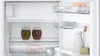 Interior view of an open refrigerator, showing shelves stocked with food items. Produktbild-Vorschau