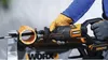 A person wearing gloves is using a reciprocating saw to cut a pipe. Voir les images du produit