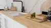 A close-up view of a modern kitchen countertop with a sink, faucet, and various kitchen items. Produktbild-Vorschau