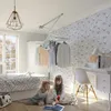 Two young girls are sitting on the floor in a bedroom, reading a book. A clothes drying rack is mounted on the ceiling. Podgląd zdjęcia produktu