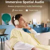 A young man wearing headphones and listening to music while sitting on a couch. Anteprima dell’immagine prodotto