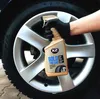 A gloved hand holds a bottle of K2 BOLD Tyre Care product in front of a car wheel. Podgląd zdjęcia produktu