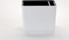 A white planter with horizontal lines and a black top rim sits on a white surface. Náhled obrázku produktu