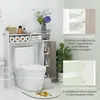 A bathroom shelf unit positioned over a toilet, with decorative elements and plants. Voir les images du produit