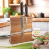 A wooden and resin knife block with two knives is displayed on a table, with tulips and a glass of drink in the foreground and a kitchen in the background. Podgląd zdjęcia produktu