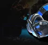 Close-up of a gaming headset with blue accents and LED lighting, set against a dark, abstract background with hints of fire or explosions. Produktbild-Vorschau