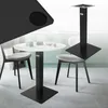 A black table base is shown in a modern dining room setting with a white table and chairs. Náhľad obrázku produktu