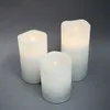 Three LED candles of varying heights are arranged on a plain gray background. Produktbild-Vorschau