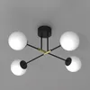 A modern ceiling light fixture with four spherical white lamps and a black and gold frame, shown against a plain gray background. Podgląd zdjęcia produktu