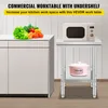 A commercial work table with a microwave and a pot on it, next to a cabinet with vegetables on top. Podgląd zdjęcia produktu