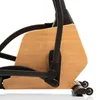 A close-up side view of the base of an elliptical trainer, showing a wooden panel and black metal frame. Podgląd zdjęcia produktu