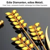 Close-up of decorative branches with yellow gem-like accents on a black reflective surface. Produktbild-Vorschau