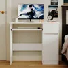 A white computer desk with a monitor, keyboard, and a drawer unit, set in a room with a bed and wall decorations. Podgląd zdjęcia produktu