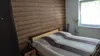 A bedroom with a bed and a wooden-paneled wall. Podgląd zdjęcia produktu