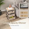 A KOMFOTTEU dresser with three fabric drawers is shown next to a sofa, with a decorative bunny on top. An inset image shows how clothing can be stored in the drawers. Podgląd zdjęcia produktu