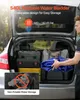 A man is loading a blue foldable water bladder into the trunk of a car, which is filled with other items. Voir les images du produit