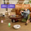 A living room scene with a robot vacuum cleaner, a cat, and two people playing video games. Produktbild-Vorschau