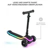 A black Kinderkraft scooter with colorful LED lights on the platform and wheels, shown against a white background. Text overlays describe features. Náhled obrázku produktu