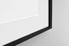 A close-up view of a framed picture with a white mat and a black frame. Produktbild-Vorschau
