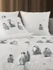 A bed with pillows and bedding featuring a penguin print. Produktbild-Vorschau