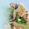 An older man is using a mini chainsaw to cut a log in an outdoor setting. Náhľad obrázku produktu