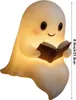 A glowing ghost figurine holding an open book. Produktbild-Vorschau
