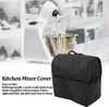 A kitchen mixer and its cover are displayed on a table with a blurred background of shelves. Produktbild-Vorschau