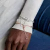 A close-up shot of a person's arm wearing two Pandora charm bracelets. Anteprima dell’immagine prodotto