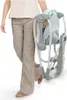 A person is holding a folded baby swing. Produktbild-Vorschau