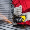 A person wearing work clothes and gloves is using an angle grinder to cut metal, creating sparks. Produktbild-Vorschau