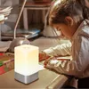 A young girl is doing homework at a desk, illuminated by a bedside lamp. Podgląd zdjęcia produktu