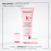 A pink bottle of Kerastase Genesis fondant renforçateur is displayed on a white background, supported by pink acrylic blocks. Náhled obrázku produktu