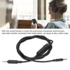 A woman wearing headphones is looking at her phone, with a close-up of a black headset cable below. Podgląd zdjęcia produktu