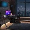A modern gaming setup in a room at night, with a city skyline visible through a large window. Produktbild-Vorschau