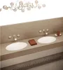 A bathroom vanity with two sinks, faucets, a towel, and a soap dispenser. Produktbild-Vorschau