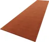 A long, narrow rug with a textured surface, laid out diagonally on a white background. Produktbild-Vorschau