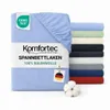A stack of folded bed sheets in various colors, with one sheet prominently displayed in the foreground with product information. Produktbild-Vorschau