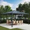 A gazebo with a dining set set up underneath in a backyard setting. Náhled obrázku produktu