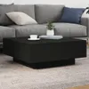 A black coffee table with a cup and a plant on it, placed in a living room setting with a gray sofa. Produktbild-Vorschau