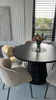 A dining table with chairs and a vase of flowers. Produktbild-Vorschau