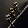 Three faucet heads with faceted designs are arranged diagonally on a reflective black surface. Podgląd zdjęcia produktu