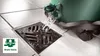 Water being drained from a green container into a floor drain. Voir les images du produit