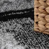 A close-up view of a rug with a woven basket in the foreground. Produktbild-Vorschau
