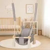 A baby swing is set up in a nursery next to a crib and a shelf unit. Náhled obrázku produktu