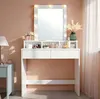 A white vanity table with a lighted mirror and makeup products displayed on top. Produktbild-Vorschau