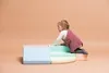 A baby is climbing on a set of colorful foam climbing blocks. Podgląd zdjęcia produktu