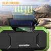 A green and black portable speaker with a solar panel on top, set against a rocky, mountainous outdoor background. Podgląd zdjęcia produktu