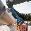 A person wearing gloves is using a cordless angle grinder to cut a large metal pipe. Produktbild-Vorschau