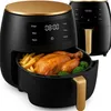 A black and gold air fryer with a cooked chicken and french fries inside. Produktbild-Vorschau